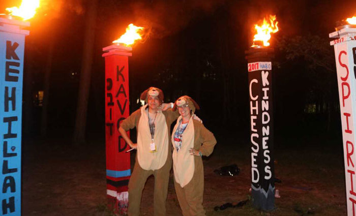 two people dressed up in dog costumes surrounded by burning torches