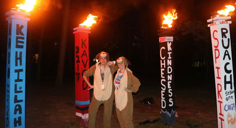two people dressed up in dog costumes surrounded by burning torches