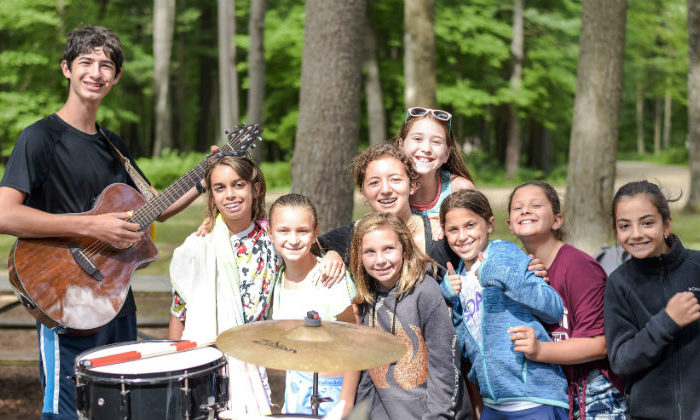 group of girls posing with a boy playing guitar