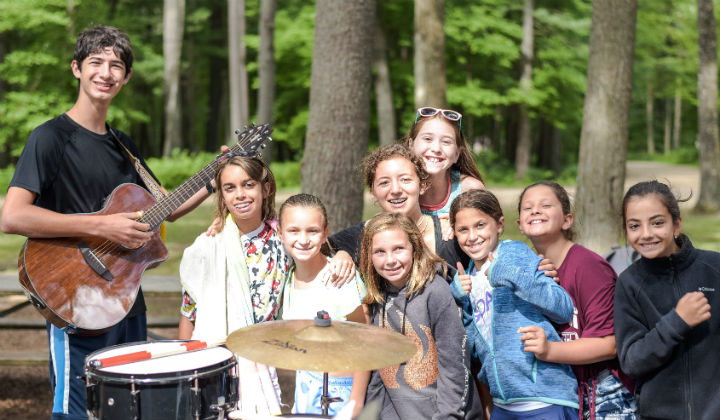 group of girls posing with a boy playing guitar