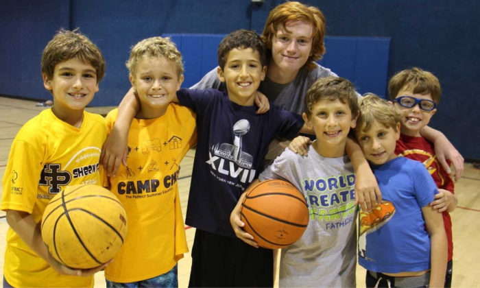 campers with their arms around each other while holding basketballs