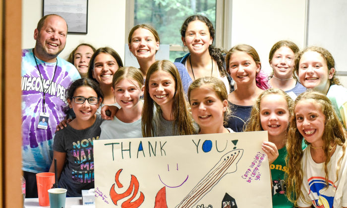 group of campers holding handwritten thank you sign