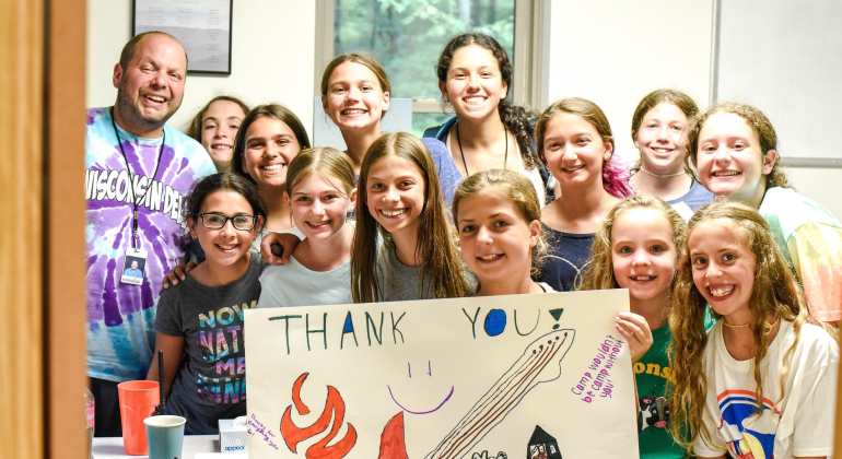 group of campers holding handwritten thank you sign