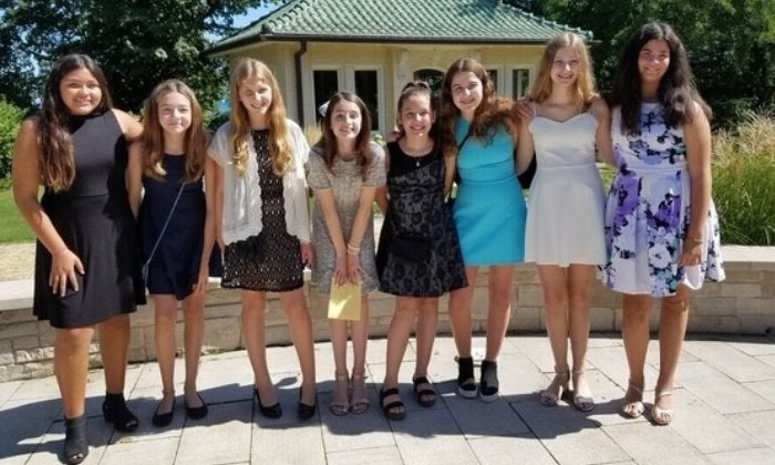 teenage girls wearing dresses smiling for camera together