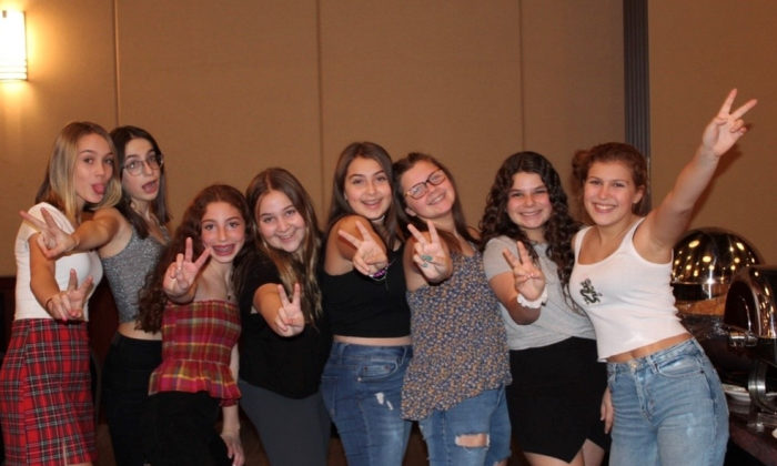 group of girls holding up peace signs