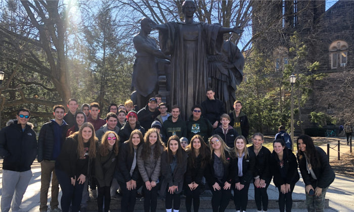 group of students standing by alma mater statue