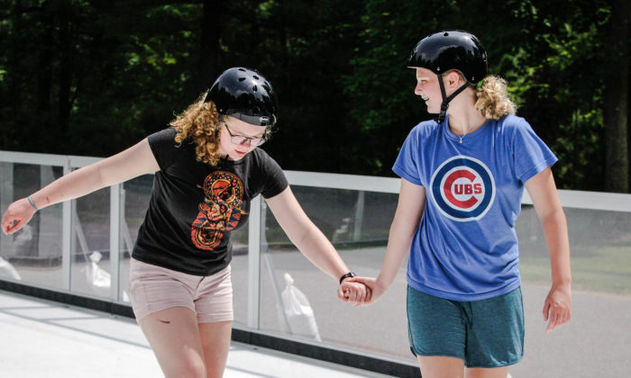 campers holding hands and skating together