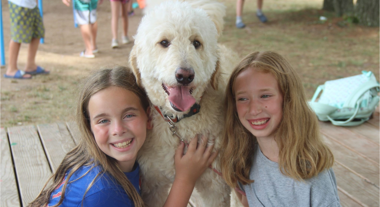 two girls posing with big white dog