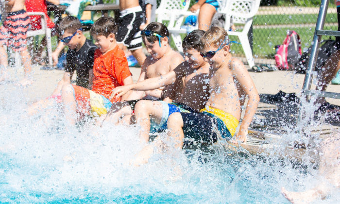 group of boys splashing their feet in the pool