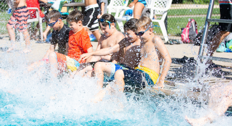 group of boys splashing their feet in the pool