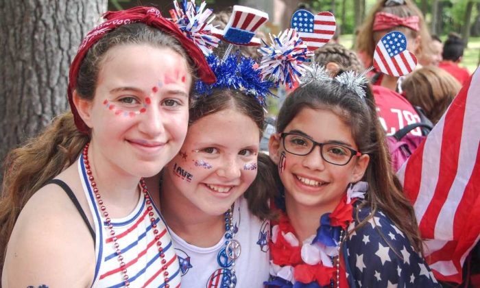 girl campers with red white and blue face paint/outfits smiling for camera