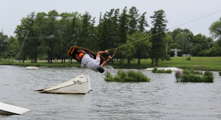 camper doing a cool trick on water skis