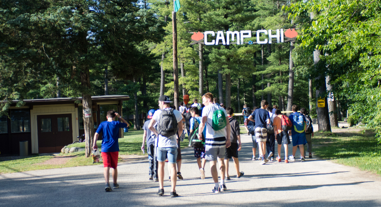 campers and counselors walking through camp entrance