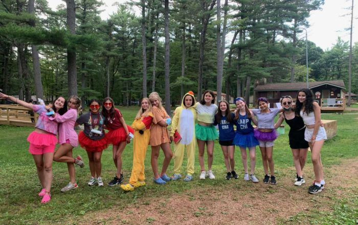 campers wearing different costumes lined up in rainbow order