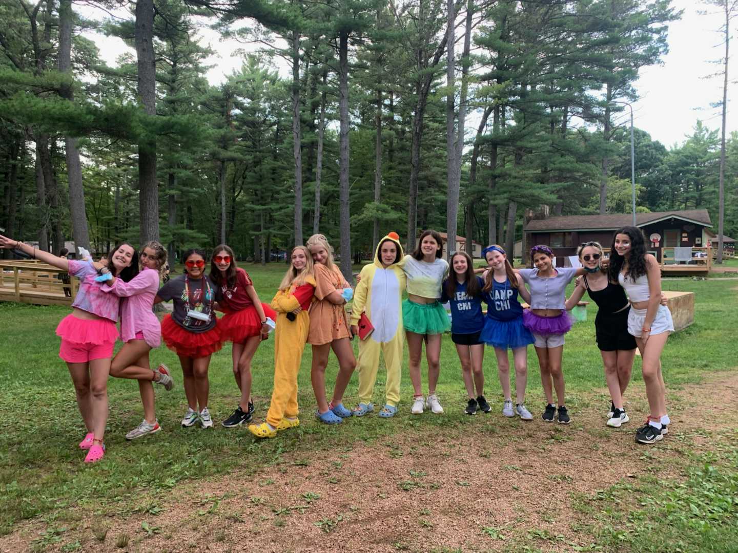 campers wearing different costumes lined up in rainbow order