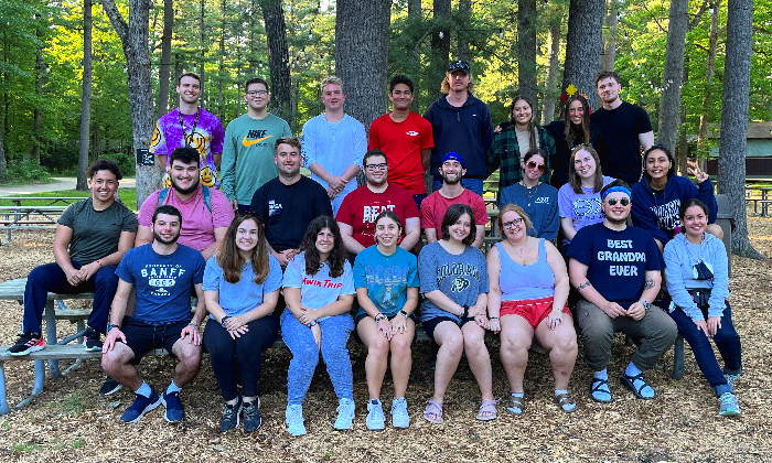 group picture of staff members sitting on picnic tables